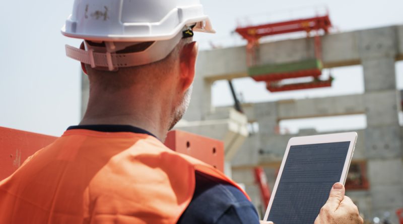 Construction worker holding an iPad at construction site