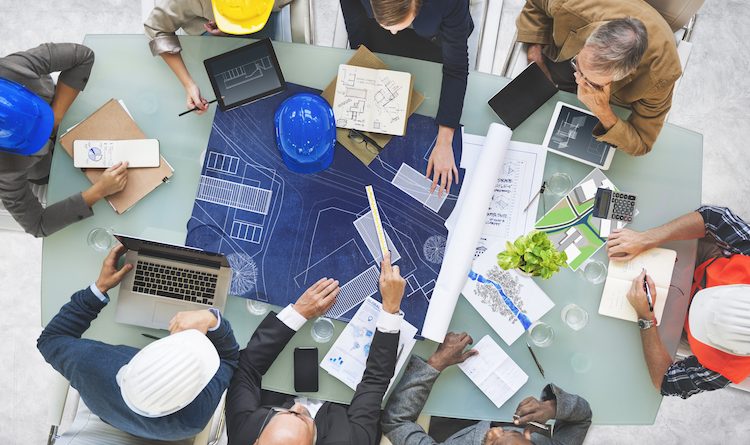 Architects & builders around a table looking at blueprints