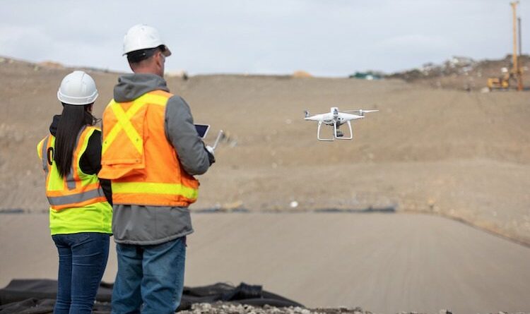 Two people in High Visibility jackets operating a drone
