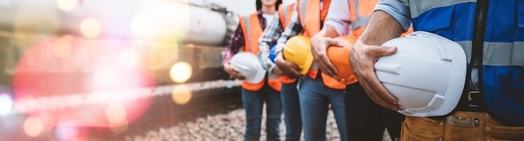 Construction workers in High visibility jackets carrying hard hats