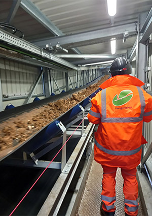 A Hargreaves worker next to part of the 650m conveyor system it has constructed on a section of the HS2 route near Aylesbury