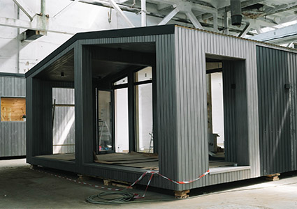 A new wooden modular prefabricated house inside in manufacturing facility.