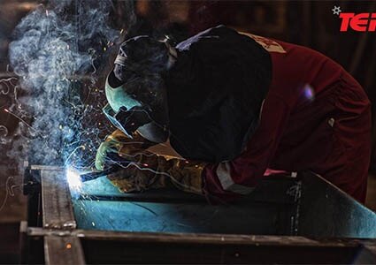 Welder working on box steel frame