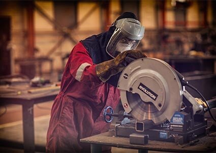 Engineer cutting box section steel with a chop saw