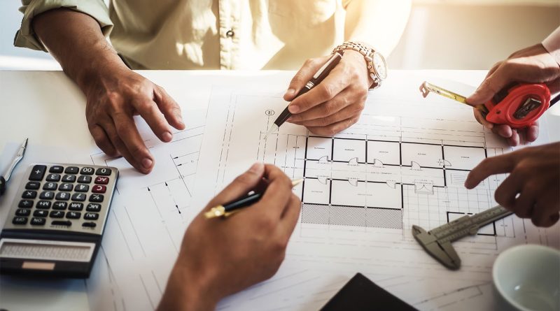 Image of a group of construction professionals gathered around a table writing down notes to support UK construction article