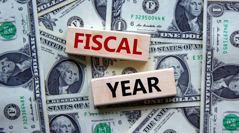 Image of multiple US dollars laid on top of each other, with the words 'fiscal year' placed over the top to support Wates Group article