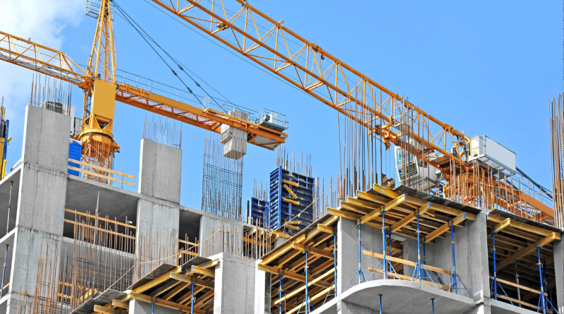 Concrete frame under construction with steel reinforcements and tower cranes, illustrating Type I building construction.